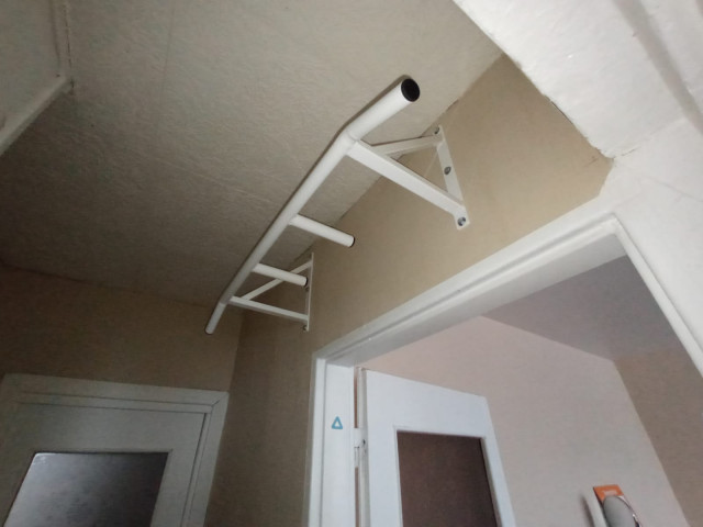 Pievilkšanās stienis ar slīpiem un papildus rokturiem (virs durvīm)