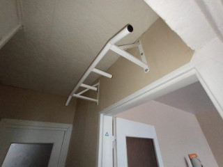 Pievilkšanās stienis ar slīpiem un papildus rokturiem (virs durvīm)